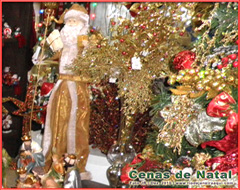 Diferente versão de boneco de papai noel e muitos enfeites decoram uma árvore e cena de natal