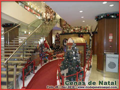 Decoração e exposição de natal em shopping center, com papai noel, pinheiros, luzes e presentes