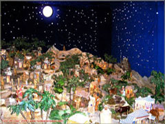 Presépio de Natal com peças e miniatura sob representação de céu estrelado