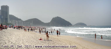 Praia de Copacabana tem o Morro do Leme ao fundo e um hotél em prédio altíssimo