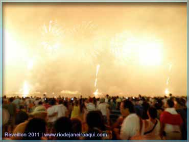 Um imenso clarão se formava enquanto muitos fogos explodiam no ar durante a queima de fogos na praia