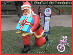 Papai Noel segurando presente feito em papier machê