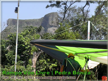 Piloto de asa delta prepara o vôo tendo a Pedra da Gávea ao fundo